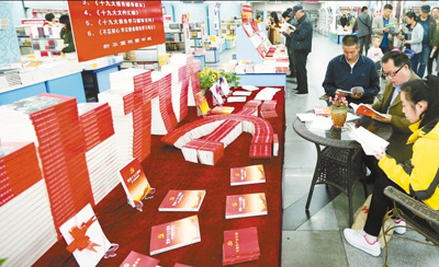 十一月五日，读者在新疆乌鲁木齐市新华国际图书城党的十九大读物展台前翻阅选购十九大学习辅导读物。