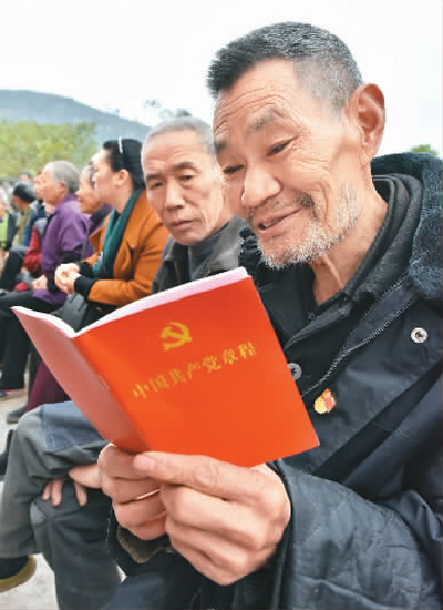 重庆市丰都县虎威镇红岩村7社，老党员李明友在十九大精神院坝宣讲会上认真学习新《党章》。 