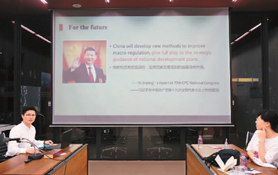 在泰国朱拉隆功大学，清华大学公共管理学院博士生石智丹（左）用英文讲解中国国家治理中的五年规划 　　霍元东摄