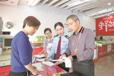 图为“五一”期间，浙江省淳安县纪委监委联合税务部门对当地土特产店进行检查，核对销售台账和相关票据清单。毛勇锋 摄