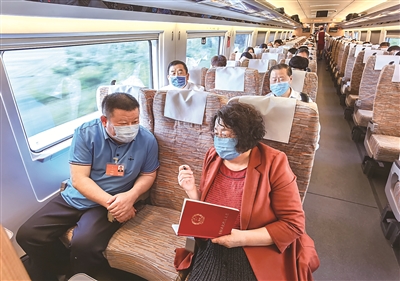 5月20日，出席十三届全国人大三次会议和全国政协十三届三次会议的河北省代表委员赴京报到。这是代表们在车厢里讨论关心关注的热点话题。赵威 摄