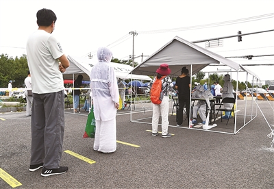 6月15日，在北京市丰台区新村街道的一处临时核酸采样点，前来检测的市民有序排队进行检测采样。  新华社记者 任超 摄
