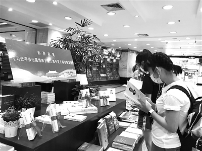 图为读者近日在上海书城设置的《习近平谈治国理政》第三卷专架展台前阅读。 外文出版社供图