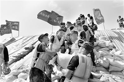 7月以来,江西多地连降暴雨,九江、上饶、南昌等地遭受严重洪涝灾害。危急关头,武警江西总队闻“汛”而动,迅速组织官兵全力投入抗洪抢险战斗。图为官兵在九江彭泽县芙蓉墩圩堤搬运沙袋。新华社发(洪水平 摄)