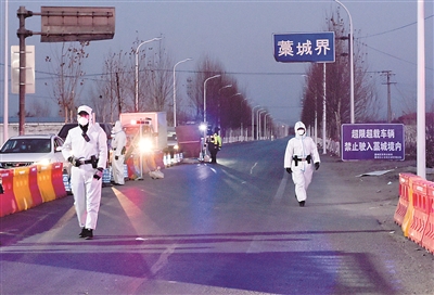 1月5日，在河北省303省道石家庄市藁城区界疫情检测点，工作人员对过往车辆进行仔细检测，同时保证道路正常通行。赵杰 摄