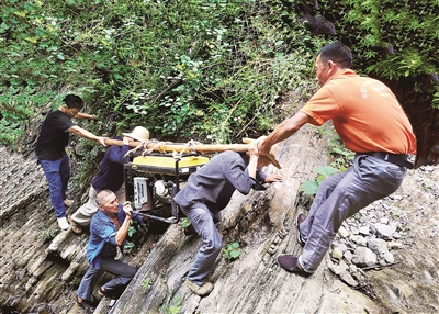 重庆市巫山县两坪乡溪沟村长期季节性缺水，为切实解决缺水难题，村干部带领群众上山寻水。图为2020年6月，该村干部群众抬着百余斤重的发电机穿越陡峭的悬崖，把海拔800多米高的山泉水引到村上蓄水池。苏耀波 摄