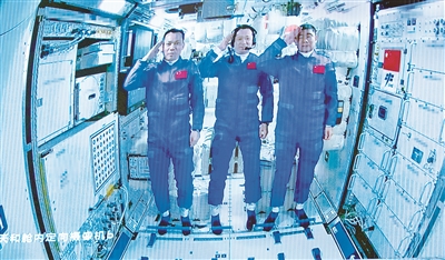 图为6月17日在北京航天飞行控制中心拍摄的进驻天和核心舱的航天员向全国人民敬礼致意的画面。 新华社记者 金立旺 摄