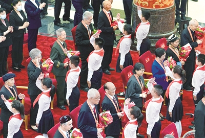 6月29日，庆祝中国共产党成立100周年“七一勋章”颁授仪式在北京人民大会堂金色大厅隆重举行。图为少先队员向勋章获得者献花，敬礼致意。新华社记者 高洁 摄