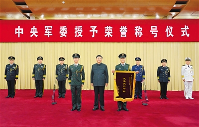 7月5日,中央军委授予荣誉称号仪式在北京隆重举行。中央军委主席习近平向获得“反恐尖刀中队”荣誉称号的武警部队新疆维吾尔自治区总队某机动支队特战大队特战1中队颁授奖旗,并同该中队代表合影留念。 新华社记者 李刚 摄
