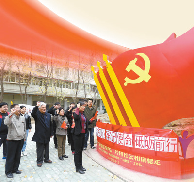 10月19日，新疆维吾尔自治区乌鲁木齐市碱泉东社区党支部组织党员群众在社区七彩党建主题文化园学习十九大报告。图为社区组织党员重温入党誓词。