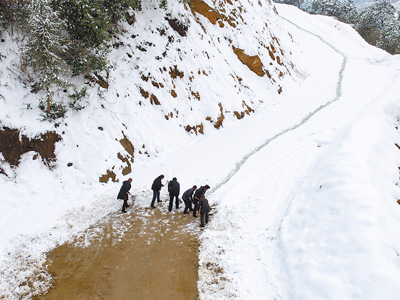 湖北罗田县蛇家山村村民冒着严寒在乡村公路上清铲积雪(1月28日摄)。 邱亚林摄