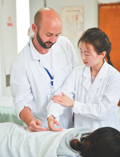 2017年7月,11名西班牙“洋中医”来到位于昆明市的云南省中医院学习推拿和针灸。图为中国老师指导“洋中医”。 人民视觉
