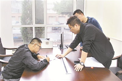 图为李昊（左一）在谈话笔录上签字。 尹兆书 摄