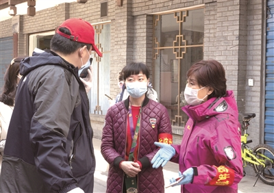 湖北省襄阳市水星台社区党委书记刘晓琳(右一)在和社区工作人员交流防疫工作。 新华社发(谢剑飞 摄)