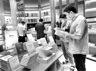 ▶图为读者近日在人民出版社旗舰店设置的重点推荐展台前阅读。 (人民出版社供图)
