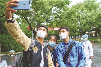 10月13日，刑法修正案（十一）草案二审稿提请十三届全国人大常委会会议审议。草案规定，冒名顶替上大学拟入刑。图为9月19日，中南民族大学2020年级新生开始入学报到。从深山中走出的少数民族大一新生拉毛东智、群热吉和关却才让（从左至右）在校园内拍照留念。新华社记者 刘金海 摄