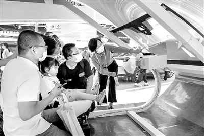 图为在第三届数字中国建设峰会期间，福耀集团展区展出的最新的车载智能投屏玻璃吸引不少观众。图为几名观众在工作人员讲解下现场体验。 魏影 摄