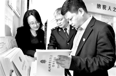 国家税务总局南昌市税务局党委纪检组强化减税降费税收优惠政策落实情况监督,图为该组纪检干部到南昌县税务局小蓝经济技术开发区税务分局查阅台账,进行监督检查。万先荣 摄