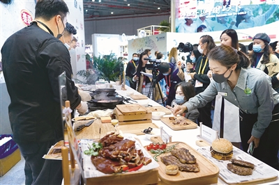 在国别数最多的食品及农产品展区,观展人员在试吃现场烹饪的香煎谷饲西冷牛排。姜永斌 摄