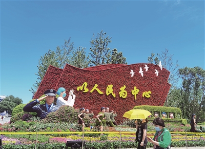 北京市长安街西单路口东北角以写有“以人民为中心”的红旗为主景的花坛。  本报记者 黄秋霞 摄