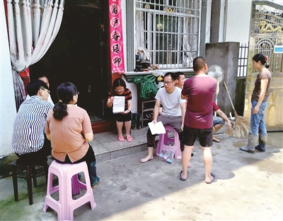 图②:2019年8月10日,安徽省绩溪县荆州乡原纪委书记李夏在抗击台风时临危受命,在转移群众过程中突遇山体塌方,以身殉职,年仅33岁。图为李夏生前光着脚在群众家门口核对灾情。汪夏寅 摄