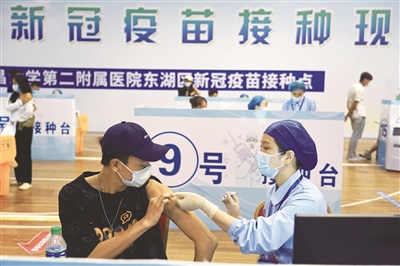 近日，在江西省体育馆方舱接种点，南昌大学第二附属医院的医护人员在给大学生接种新冠疫苗。新华社记者 万象 摄