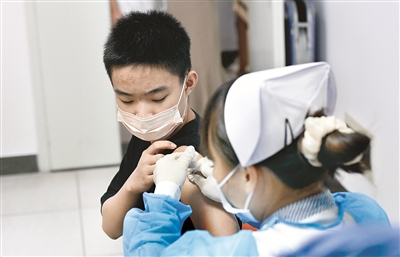 近日，海南省海口市加快推进12至17周岁人群新冠疫苗接种工作。图为8月4日，在海口市人民医院新冠病毒疫苗接种点，医护人员在为接种者接种疫苗。 新华社记者 杨冠宇 摄