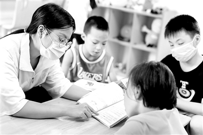 图为近日,一位社工(左一)在灵山县儿童福利院内为孩子们读书。 新华社记者 张玉薇 摄