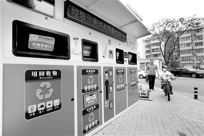 图为河北省唐山市路北区祥瑞里小区的居民从智能垃圾分类柜旁边走过。 新华社记者 杨世尧 摄