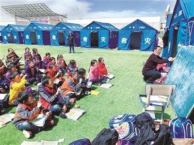 5月24日,青海省果洛藏族自治州玛多县民族寄宿制中学的学生在操场上上课。 马铭言 摄